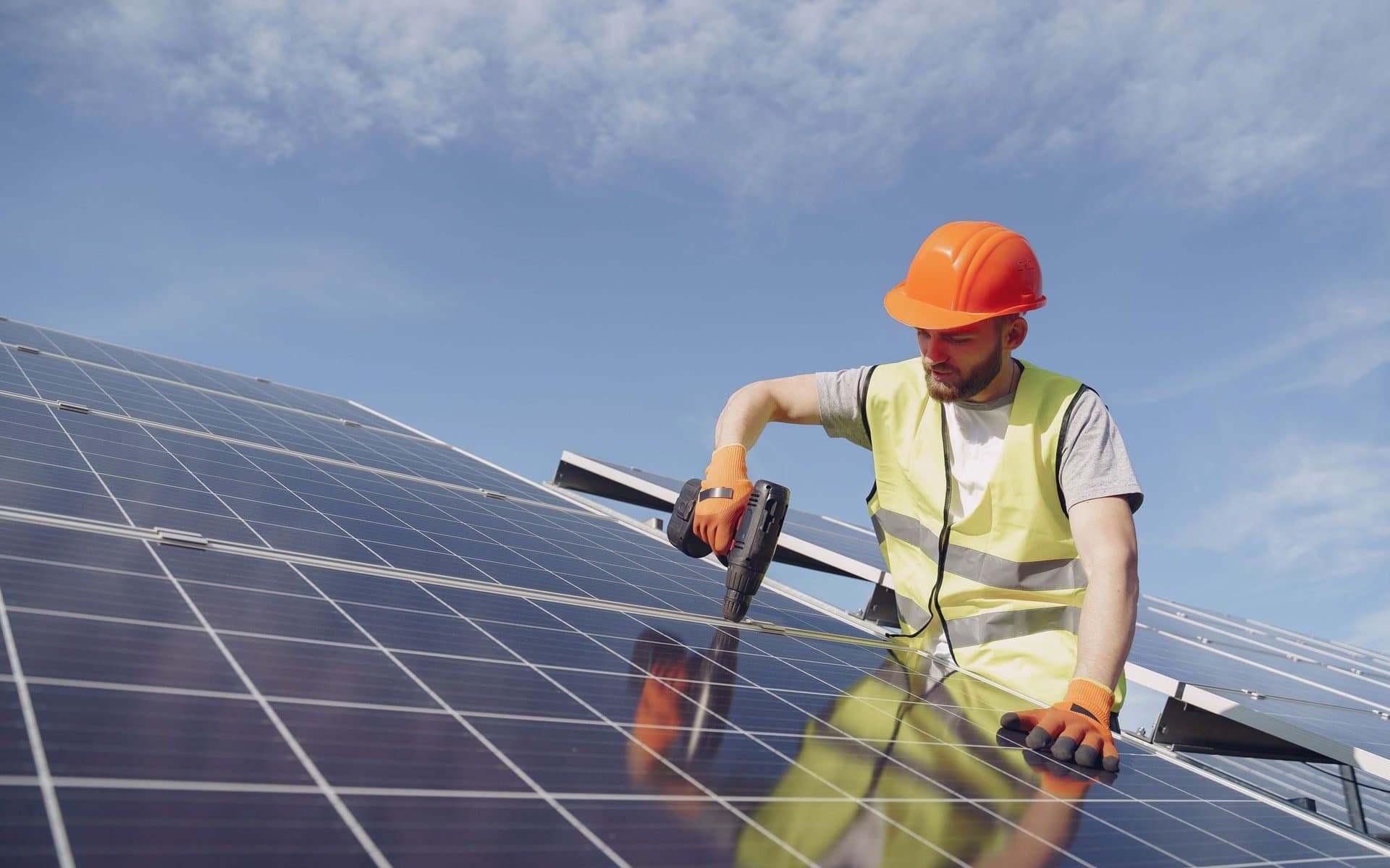 Solar installer mounting photovoltaic panels on a roof